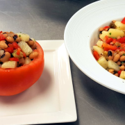 Black-eyed pea salad-stuffed tomato with salad in bowl presentation on the side